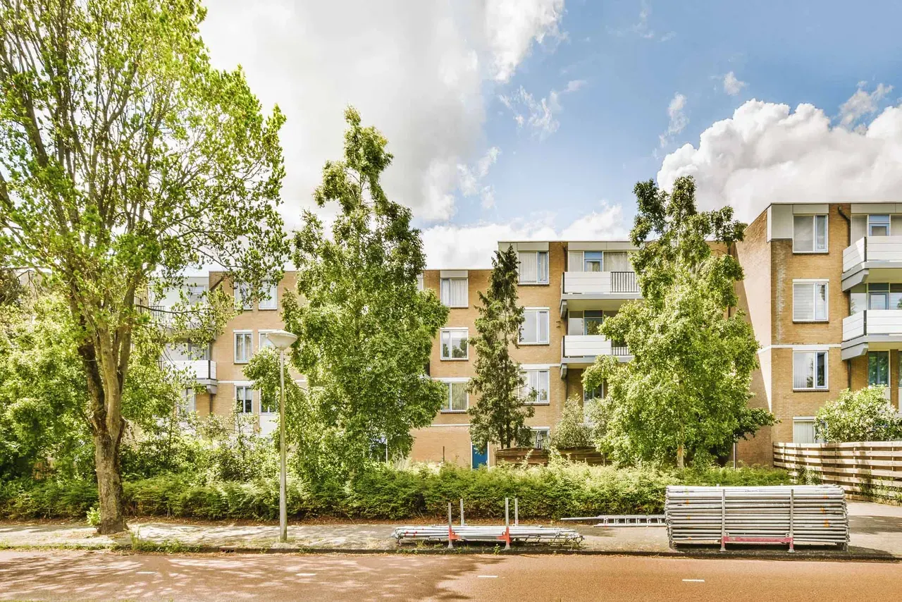 Flerbostadshus i tegel omgivna av grönska